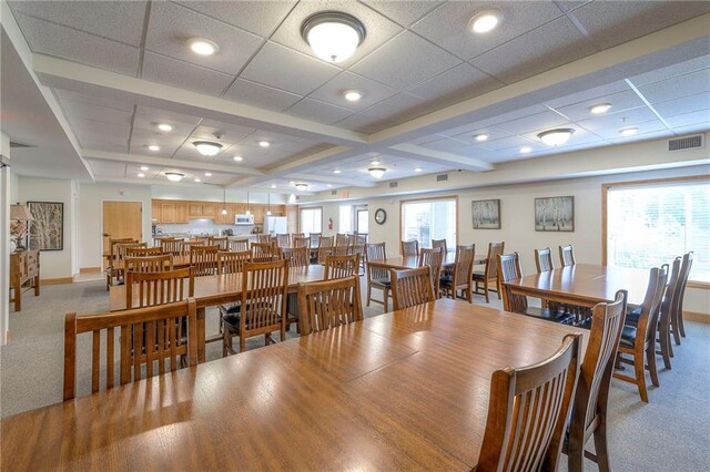 dining area with visible vents, a healthy amount of sunlight, and light colored carpet