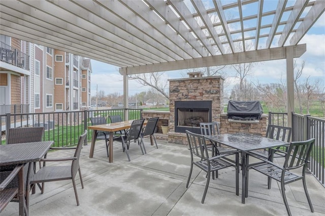 view of patio with area for grilling, an outdoor stone fireplace, outdoor dining area, and a pergola