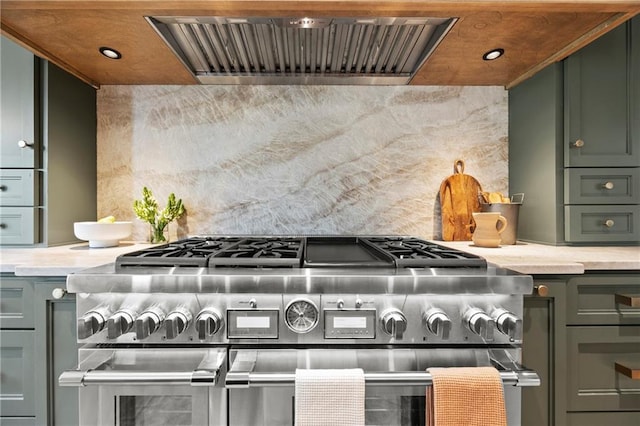 kitchen with exhaust hood, green cabinetry, light countertops, recessed lighting, and double oven range