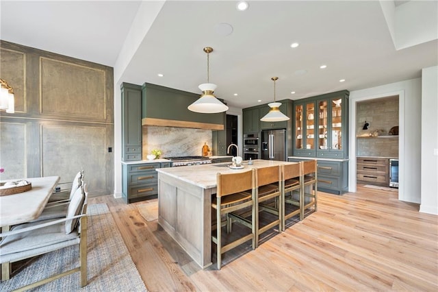 kitchen featuring beverage cooler, recessed lighting, appliances with stainless steel finishes, and tasteful backsplash
