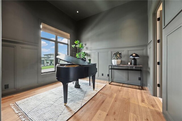 sitting room featuring light wood finished floors, a decorative wall, and wainscoting