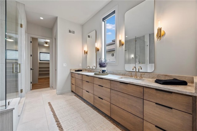 full bathroom featuring visible vents, a shower stall, a sink, and plenty of natural light