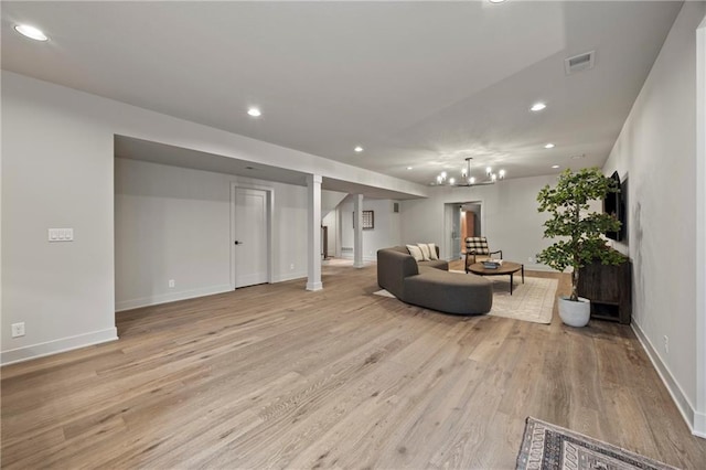 living room featuring visible vents, baseboards, a chandelier, light wood-style floors, and recessed lighting