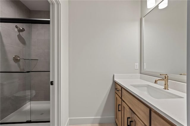 full bathroom with vanity, baseboards, and a shower stall