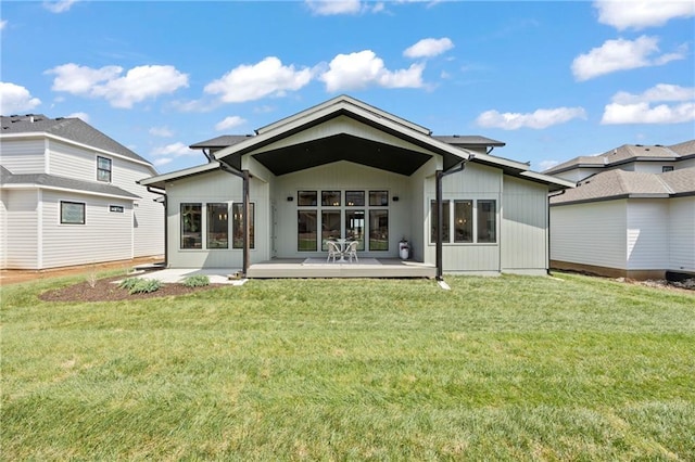 back of property with a lawn and a patio area