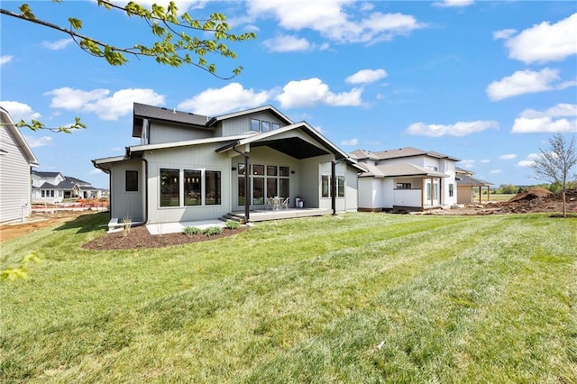 rear view of house with a lawn and a patio