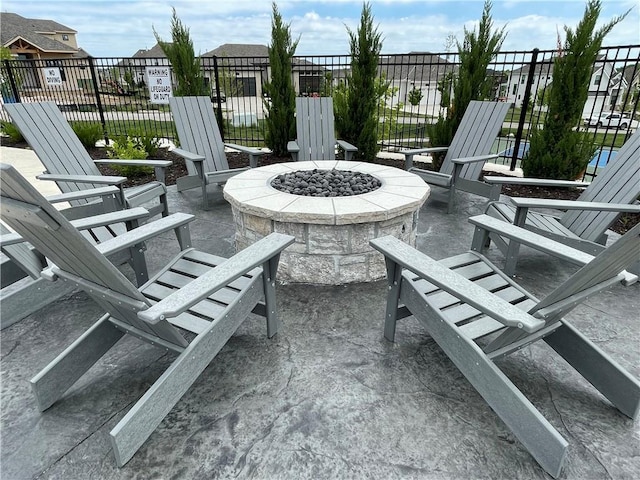 view of patio with a fire pit, fence, and a residential view