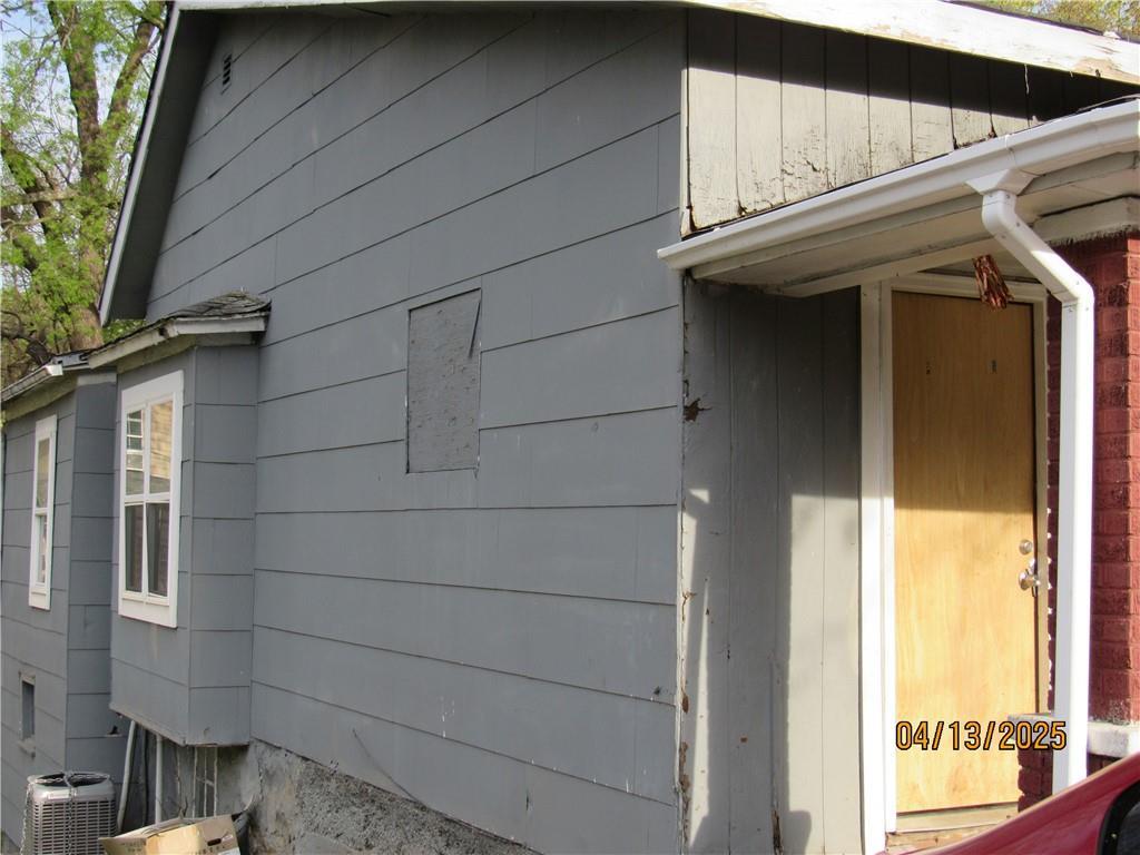 view of side of property with central air condition unit