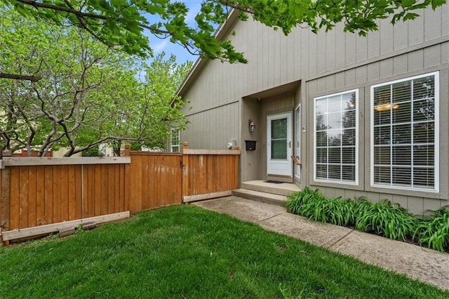 rear view of property with fence and a lawn