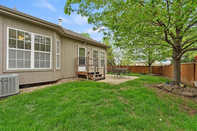 rear view of house with a lawn, a patio, central AC unit, and a fenced backyard