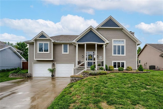 split foyer home featuring central air condition unit, an attached garage, concrete driveway, and a front yard
