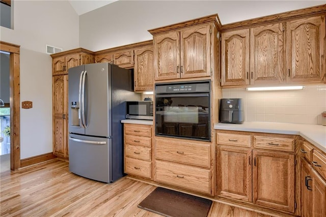 kitchen featuring visible vents, light wood-style floors, light countertops, backsplash, and stainless steel appliances