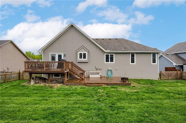 rear view of house featuring a lawn, a wooden deck, and a fenced backyard