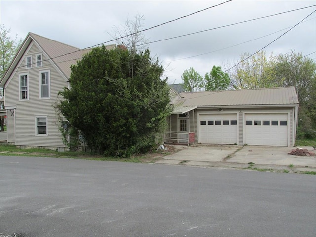 820 Custer St, Trenton, MO 64683 - view of front of home featuring a garage, concrete driveway, and metal roof