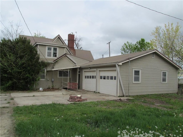 820 Custer St, Trenton, MO 64683 - view of front of home featuring a garage, a chimney, driveway, and metal roof