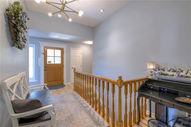 entryway featuring a chandelier, tile patterned floors, and baseboards