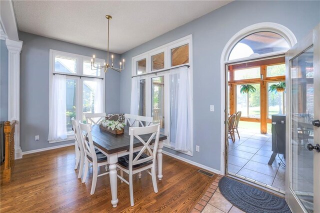 dining room featuring a chandelier, baseboards, and wood finished floors