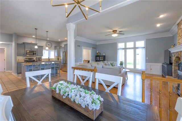 dining space with a ceiling fan, ornamental molding, a fireplace, recessed lighting, and light tile patterned floors
