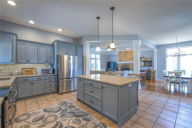 kitchen featuring stainless steel appliances, ornate columns, gray cabinets, and recessed lighting