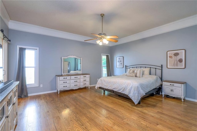 bedroom featuring ornamental molding, light wood-style flooring, baseboards, and a ceiling fan