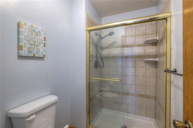 full bathroom featuring a stall shower, toilet, and a textured ceiling