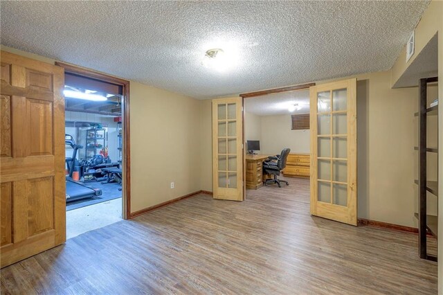 office area with french doors, wood finished floors, a textured ceiling, and baseboards