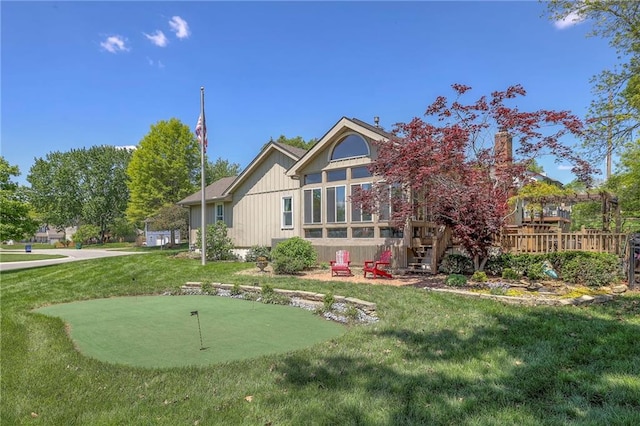 back of property featuring a putting green, a lawn, and a deck