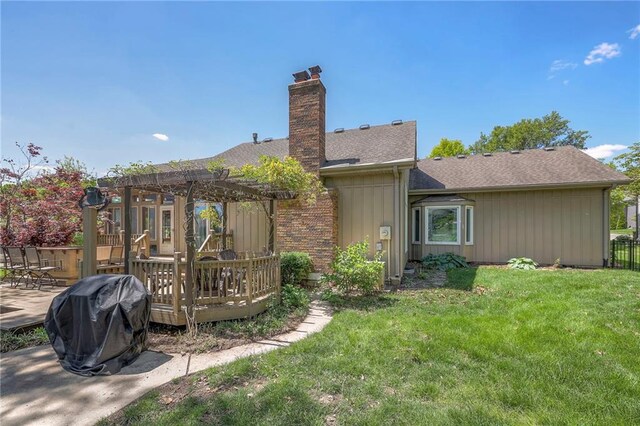 rear view of house featuring a pergola, a deck, roof with shingles, and a chimney