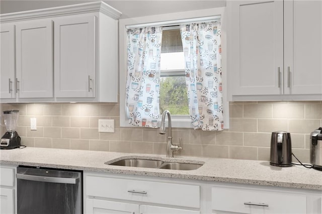 kitchen featuring decorative backsplash, light stone countertops, dishwasher, a sink, and white cabinets