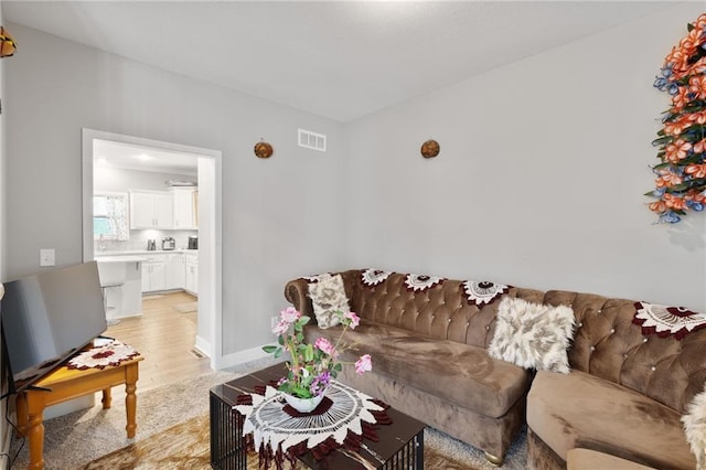 living room with visible vents and light wood-type flooring