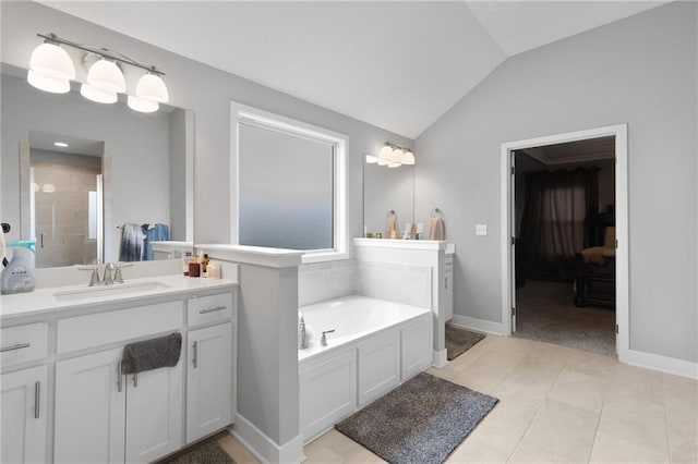 bathroom with a garden tub, vanity, lofted ceiling, tile patterned floors, and a tile shower