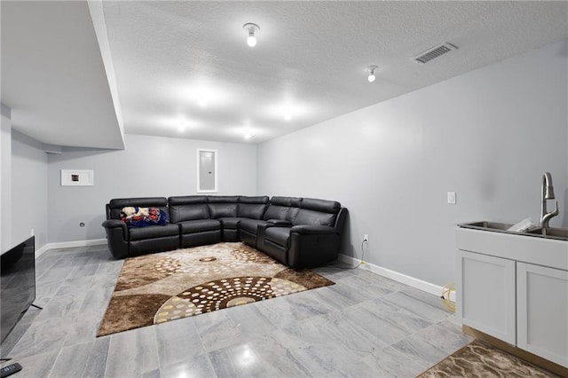 living room with visible vents, a textured ceiling, and baseboards