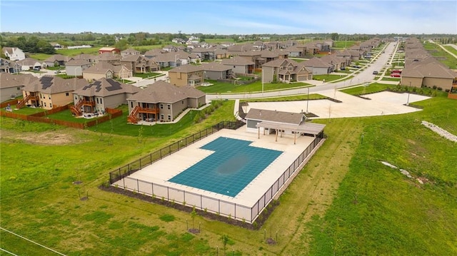 view of pool with fence, a yard, and a residential view