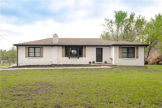 1204 E 223rd St, Cleveland, MO 64734 - view of front facade with a chimney, brick siding, and a front yard