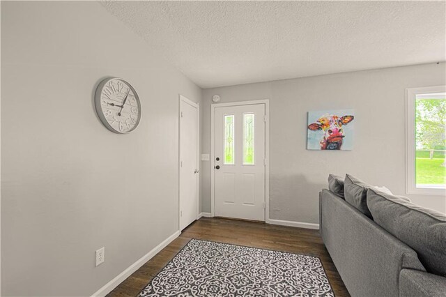 1204 E 223rd St, Cleveland, MO 64734 - entrance foyer with baseboards, a textured ceiling, and dark wood finished floors