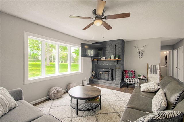1204 E 223rd St, Cleveland, MO 64734 - living area with a brick fireplace, a ceiling fan, a healthy amount of sunlight, and wood finished floors