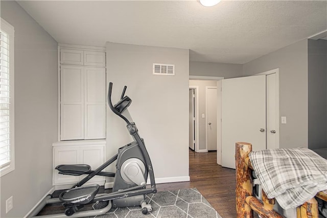 1204 E 223rd St, Cleveland, MO 64734 - exercise area featuring dark wood-type flooring, baseboards, a wealth of natural light, and visible vents