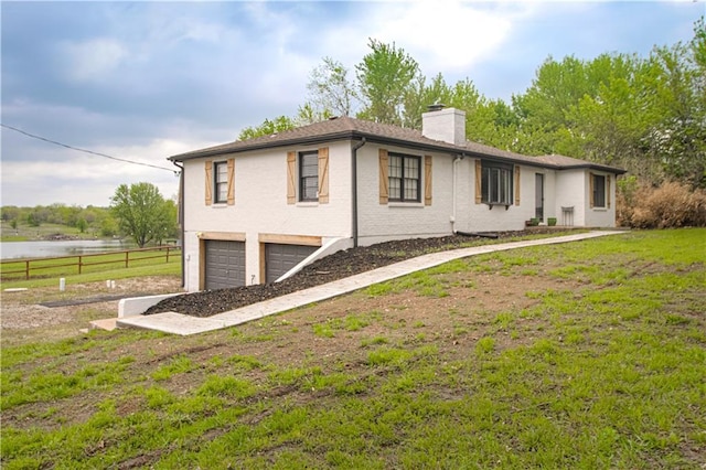 1204 E 223rd St, Cleveland, MO 64734 - exterior space featuring driveway, a chimney, a front yard, fence, and an attached garage