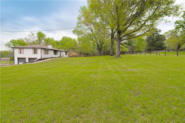 1204 E 223rd St, Cleveland, MO 64734 - view of yard with an attached garage, fence, and driveway