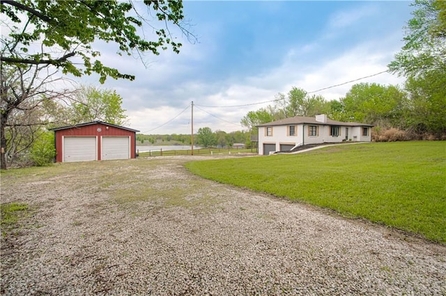 1204 E 223rd St, Cleveland, MO 64734 - exterior space featuring an outdoor structure, a garage, driveway, and a front yard