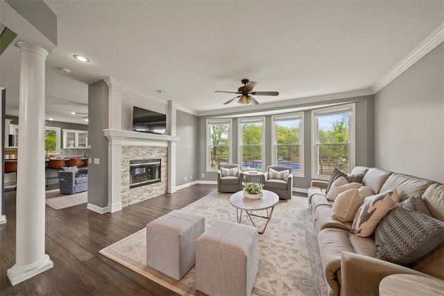 14305 S Gammon Rd, Greenwood, MO 64034 - living room with ornate columns, a ceiling fan, crown molding, dark wood-style floors, and a fireplace