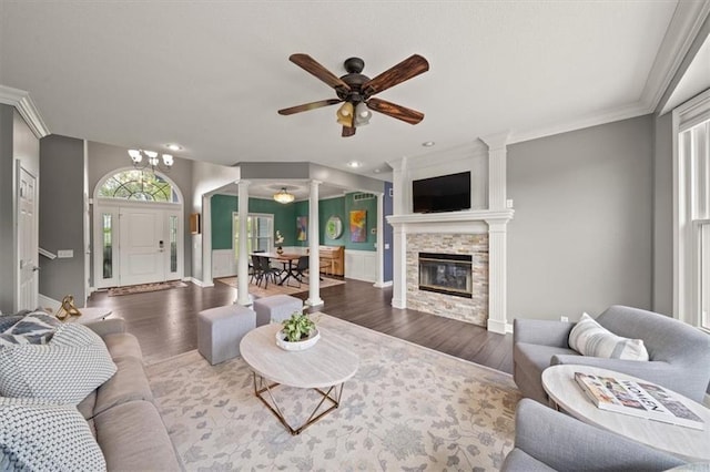 14305 S Gammon Rd, Greenwood, MO 64034 - living room with ornate columns, wood finished floors, a stone fireplace, ceiling fan, and crown molding