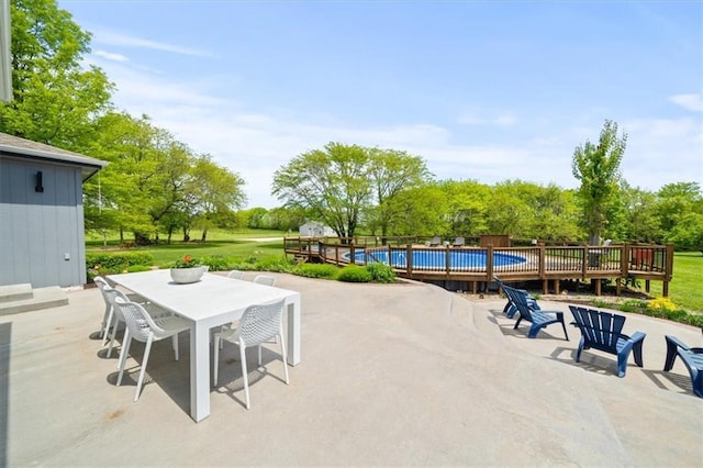14305 S Gammon Rd, Greenwood, MO 64034 - view of patio / terrace featuring an outdoor pool, outdoor dining area, view of wooded area, and a deck