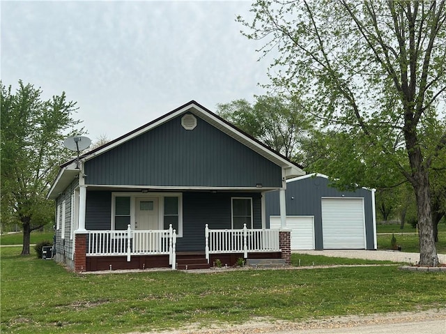 view of front of property with a detached garage, covered porch, an outdoor structure, and a front yard