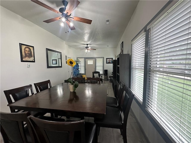 dining space featuring a ceiling fan, baseboards, visible vents, and wood finished floors
