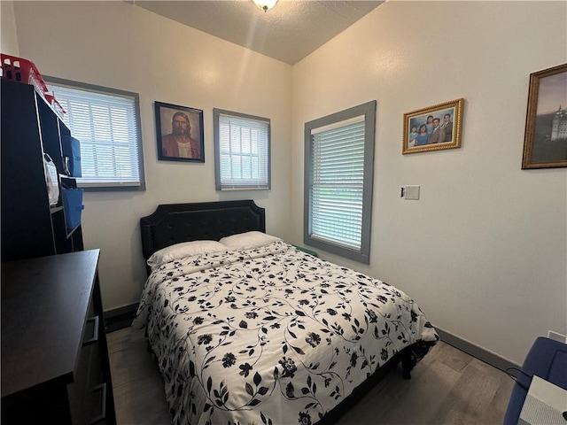 bedroom featuring baseboards and wood finished floors
