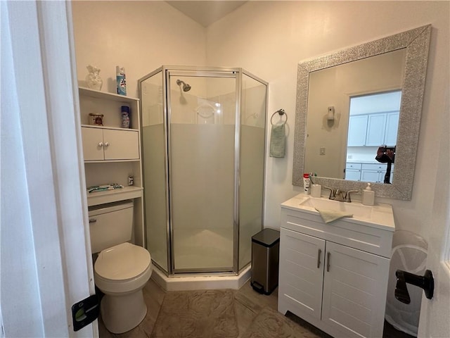 bathroom featuring vanity, a shower stall, and toilet