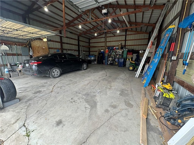 garage featuring a garage door opener, metal wall, and electric panel