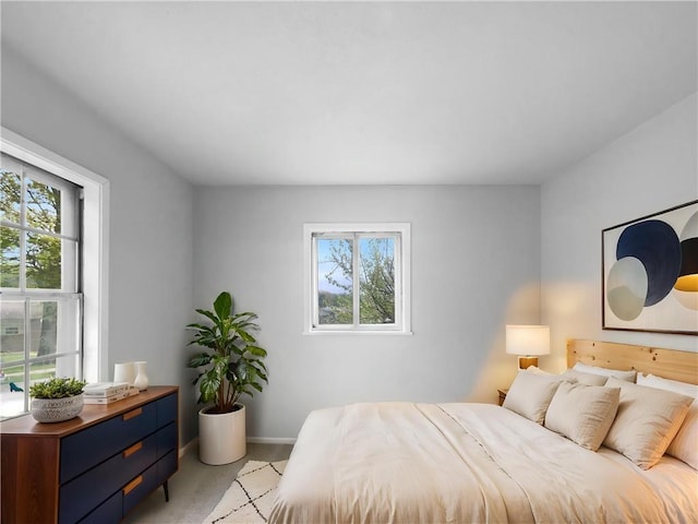 bedroom featuring baseboards and light colored carpet