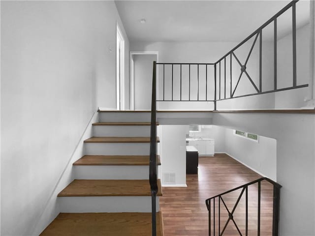 stairs featuring baseboards, visible vents, and wood finished floors